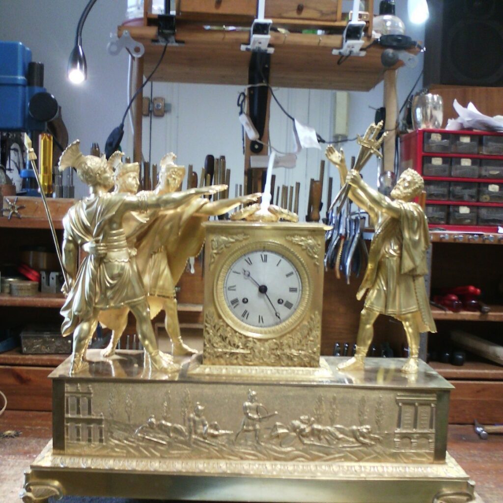 Pendule aux soldats romains en bronze doré, réparation horloge ancienne Bordeaux