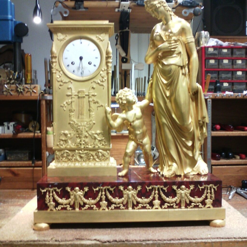 Pendule Empire en bronze doré avec figurines, restaurée à l'atelier bordelais